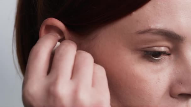 moderne gadgets, vrouw gebruikt draadloze koptelefoon om te luisteren naar muziek, close-up - Video