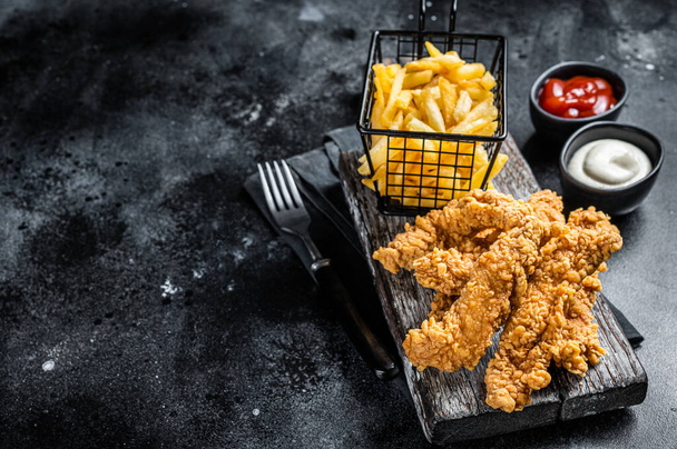 Chicken breast strips with French Fries and Ketchup. Black background. Top view. Copy space. - Foto, Imagem
