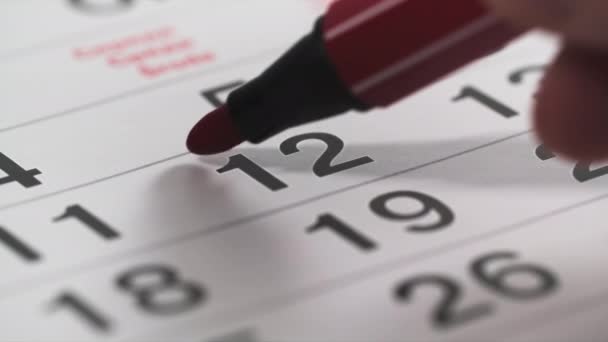 σχεδιαστής, κόκκινος μαρκαδόρος διαγράφει αριθμούς στο ημερολόγιο, κοντινό πλάνο - Πλάνα, βίντεο