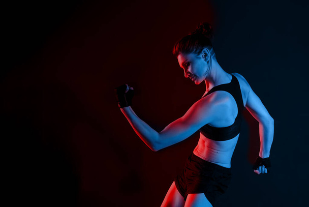 Ελκυστική αθλητικός νεαρός καυκάσιος γυναίκα κάνει άσκηση γυμναστικής. Κόκκινο και μπλε τονισμένο Πορτρέτο Φωτογραφία - Φωτογραφία, εικόνα