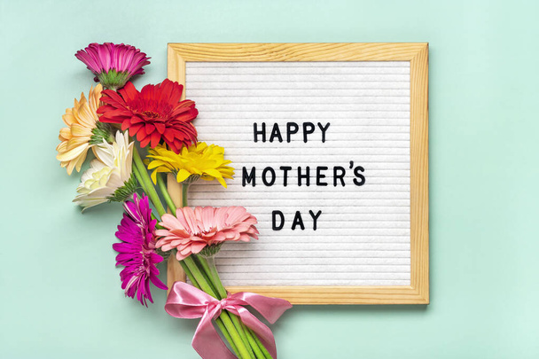 Mutlu Anneler Günü, yeşil arka plan tebrik kartı üzerinde renkli gerberas buketi Düz üst görünüm yatıyordu. - Fotoğraf, Görsel