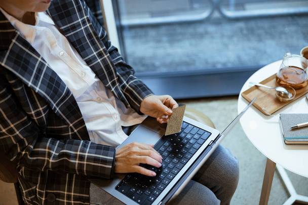 Vrouw typt op het toetsenbord terwijl u creditcardgegevens invoert om aankopen te doen. Online winkelen - Foto, afbeelding