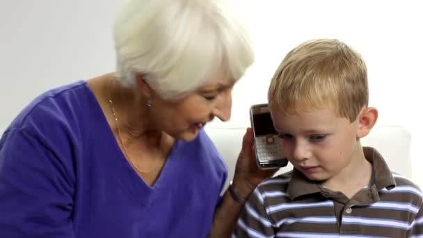 Kobieta i chłopiec rozmowy na telefon komórkowy - Materiał filmowy, wideo