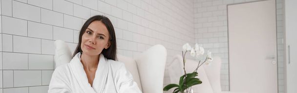 Woman in white bathrobe relaxing during medical procedure in beauty clinic. High quality photo - Foto, Imagem