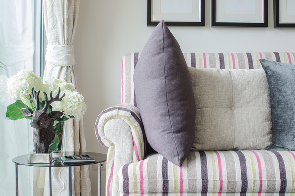 sofá colorido com almofadas e mesa de vidro na sala de estar
  - Foto, Imagem