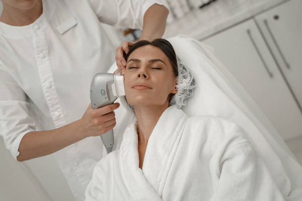 Cosmetologist is making cavitation rejuvenation skin treatment. Radio wave lifting - Foto, Imagen