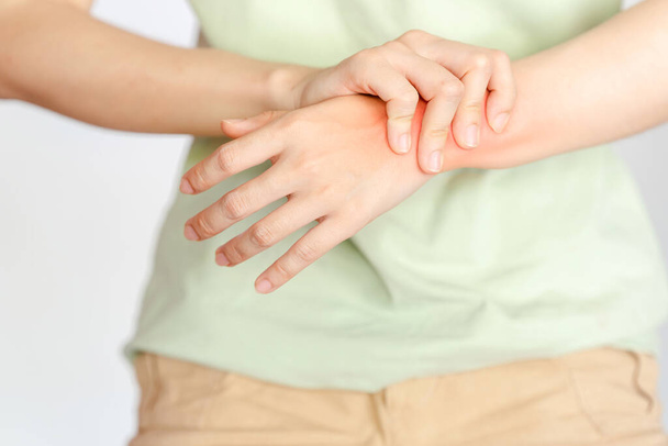 Žena držící si zápěstí kvůli zranění nebo revmatoidní artritidě. - Fotografie, Obrázek