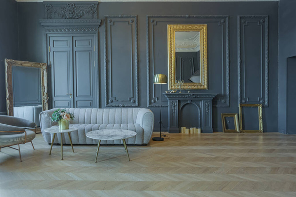 chic interior of the room in the Renaissance style of the 19th century with modern luxury furniture. walls of noble dark color are decorated with stucco and gilded frames, wooden parquet. - Foto, Bild