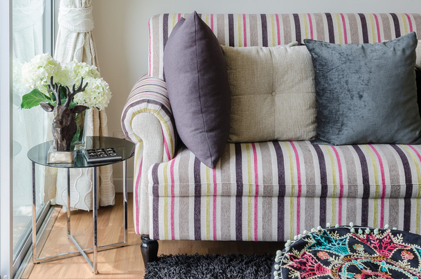 sofá colorido com almofadas e mesa de vidro na sala de estar
 - Foto, Imagem