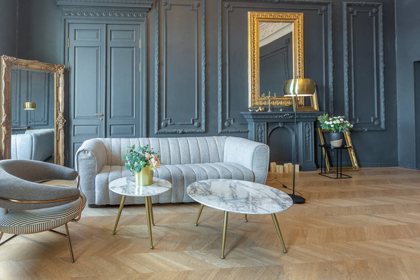 chic interior of the room in the Renaissance style of the 19th century with modern luxury furniture. walls of noble dark color are decorated with stucco and gilded frames, wooden parquet. - Valokuva, kuva
