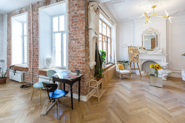 bright workshop room for the creation and work of an architect and artist in a loft style with brick walls and parquet. the walls are decorated with examples of stucco. - Foto, Bild