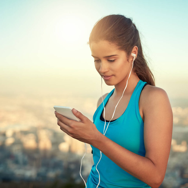 Laissez la musique être votre motivation. une jeune femme qui écoute de la musique pendant qu'elle court - Photo, image