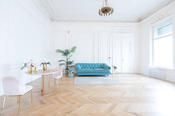 chic spacious bright apartment in an old mansion in a classic 19th century style with a high ceiling decorated with stucco molding on white walls and velvet furniture with golden elements - Photo, image