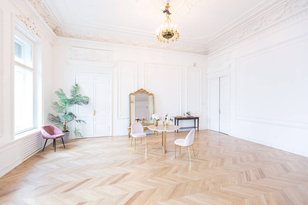 chic spacious bright apartment in an old mansion in a classic 19th century style with a high ceiling decorated with stucco molding on white walls and velvet furniture with golden elements - Fotó, kép