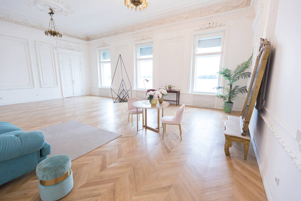 chic spacious bright apartment in an old mansion in a classic 19th century style with a high ceiling decorated with stucco molding on white walls and velvet furniture with golden elements - Fotó, kép