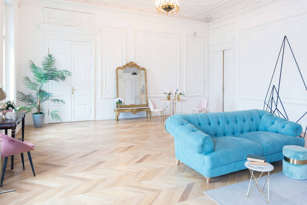 chic spacious bright apartment in an old mansion in a classic 19th century style with a high ceiling decorated with stucco molding on white walls and velvet furniture with golden elements - 写真・画像