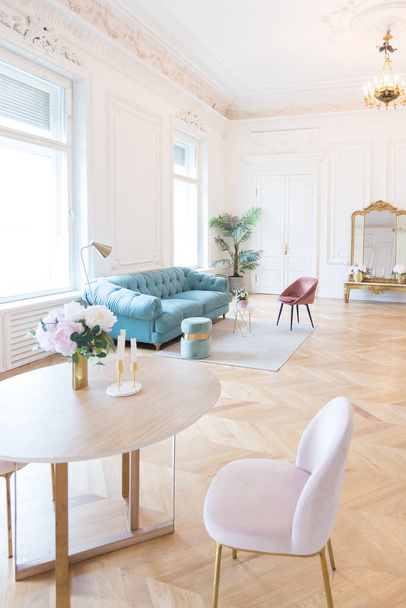 chic spacious bright apartment in an old mansion in a classic 19th century style with a high ceiling decorated with stucco molding on white walls and velvet furniture with golden elements - Foto, Imagen