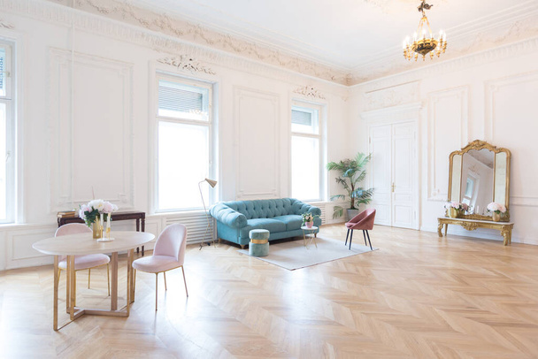 chic spacious bright apartment in an old mansion in a classic 19th century style with a high ceiling decorated with stucco molding on white walls and velvet furniture with golden elements - Foto, Imagem