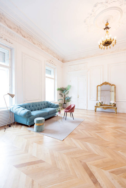 chic spacious bright apartment in an old mansion in a classic 19th century style with a high ceiling decorated with stucco molding on white walls and velvet furniture with golden elements - Photo, Image
