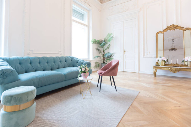 chic spacious bright apartment in an old mansion in a classic 19th century style with a high ceiling decorated with stucco molding on white walls and velvet furniture with golden elements - Zdjęcie, obraz