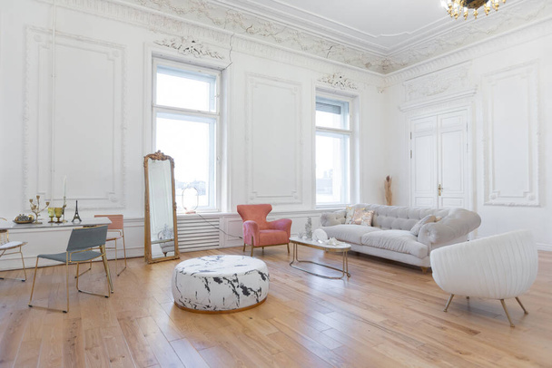 very light baroque style luxury interior of big sitting room. White walls decorated with awesome stucco. Royal style apartment with chic furniture with gold elements - Fotoğraf, Görsel