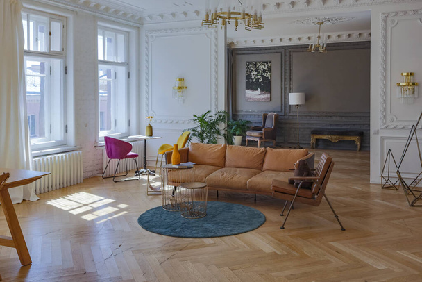 luxury interior of a spacious apartment in an old 19th century historical house with modern furniture. high ceiling and walls are decorated with stucco - Fotoğraf, Görsel