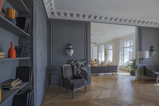 luxury interior of a spacious apartment in an old 19th century historical house with modern furniture. high ceiling and walls are decorated with stucco - Fotoğraf, Görsel