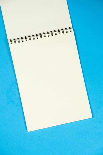 Open notitieblok op een blauwe achtergrond bovenaanzicht, ruimte voor tekst - Foto, afbeelding