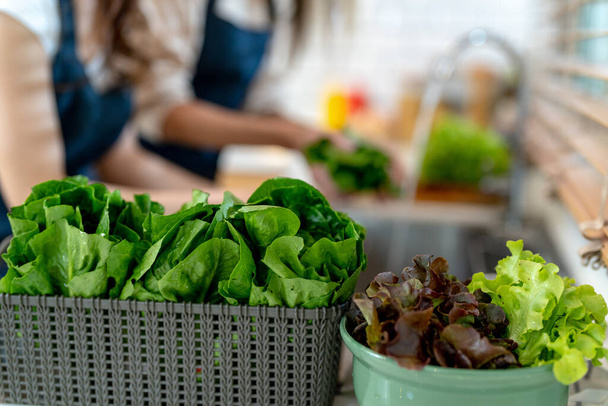 cerrar las manos preparando alimentos saludables con verduras de ensalada.La dieta limpia alimentos de productos e ingredientes locales. - Foto, Imagen