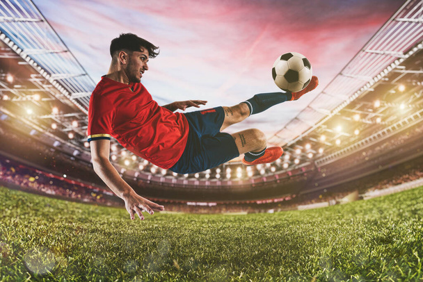 Футбольная сцена с игроком, который бьет мяч на лету на стадионе - Фото, изображение