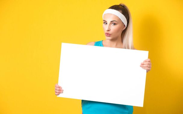 Surprised promoting women holding white board, isolated on yellow background. vitality girl showing blank empty paper billboard with blank space for text. 80s styling. Studio shot - Фото, зображення