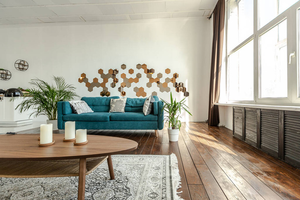 spacious studio apartment decorated with wood and white. Minimalist design with huge windows in the sunlight. kitchen area and living area - 写真・画像