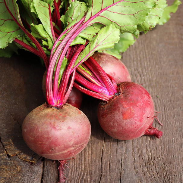 Fresh beetroot with leaves on a wooden background. Healthy food. Top view. Free space for your text. - 写真・画像