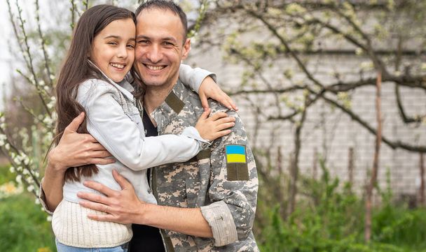 Père en uniforme militaire ukrainien et sa fille. Réunion de famille. - Photo, image