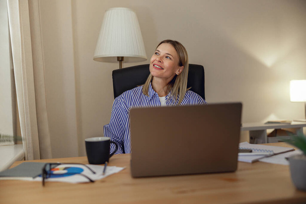 Mujer atractiva freelancer que trabaja en el ordenador portátil desde la oficina en casa. Foto de alta calidad - Foto, Imagen