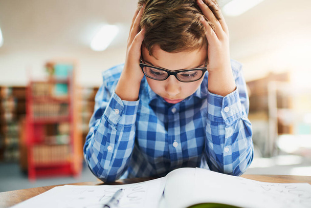 Tämä on vaikea. nuori poika, joka näyttää stressaantuneelta työskennellessään koulussa - Valokuva, kuva