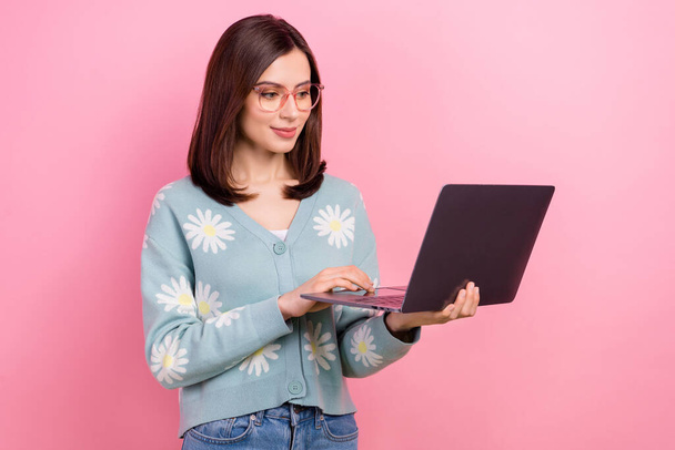 Photo of young attractive student girl preparing her last exam using her new acer laptop wear eyeglasses isolated on pink color background. - Fotoğraf, Görsel