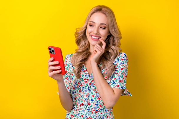 Photo of pretty cute dreamy lady blogger wear stylish clothes touch mouth use device read popular blog isolated on yellow color background. - Foto, immagini