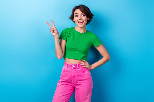 Photo of adorable girl wear stylish t-shirt showing fingers v-sign have fun carefree peaceful lady young age isolated on aquamarine color background. - Fotoğraf, Görsel