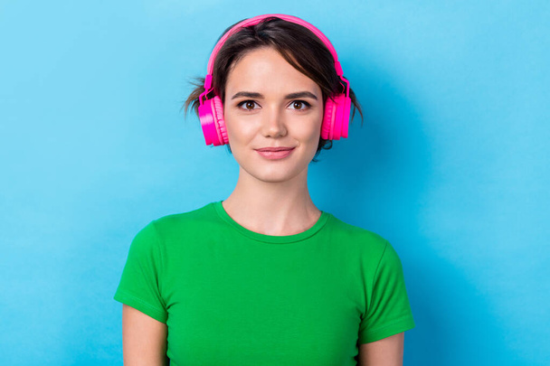 Photo of positive pretty woman dressed green top enjoying music headphones isolated blue color background. - Foto, immagini