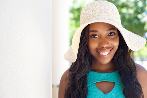 Feliz chica negra joven con pelo largo y sombrero de sol
 - Foto, Imagen