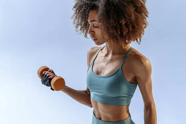Woman doing exercises with dumbbells on studio background. Sport and healthy lifestyle - Foto, Imagem
