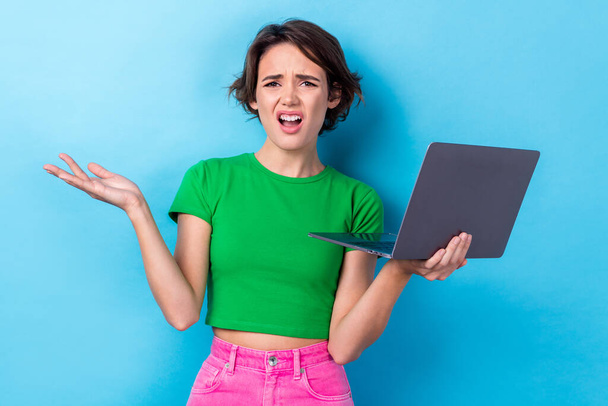 Photo of shocked impressed lady dressed green top working modern gadget isolated blue color background. - Foto, immagini