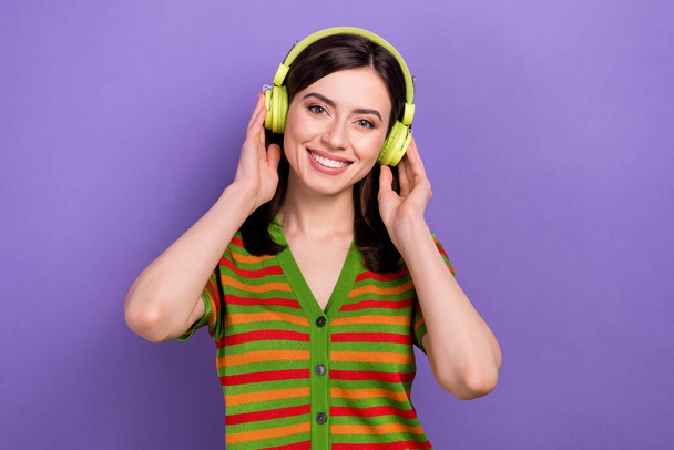 Portrait of adorable positive lady wear stylish clothes listening favorite song quality earbuds isolated on purple color background. - Foto, imagen