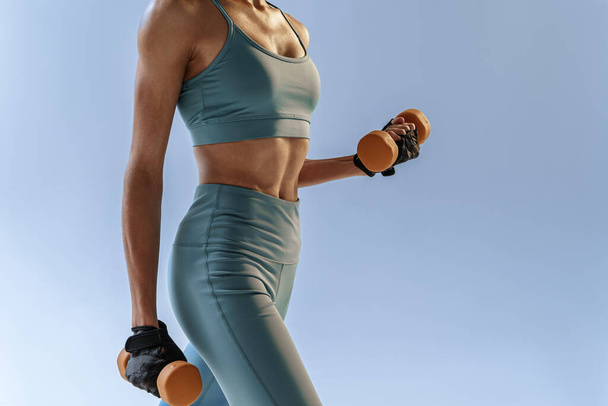 Woman doing exercises with dumbbells on studio background. Sport and healthy lifestyle - Valokuva, kuva