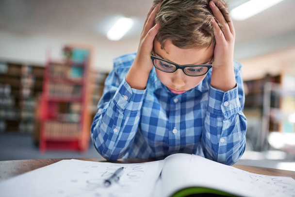 Vastaukset eivät vain tule hänelle. nuori poika, joka näyttää stressaantuneelta työskennellessään koulussa - Valokuva, kuva