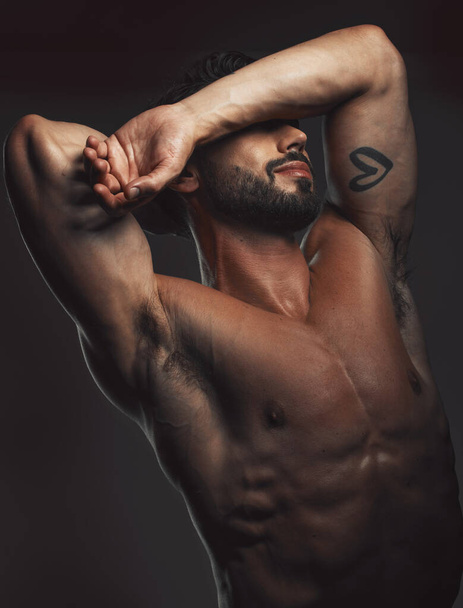 Man, body or muscle on black background in studio for fitness goals, workout or training motivation and physical wellness check. Bodybuilder, sports athlete or model flexing on aesthetic backdrop. - 写真・画像