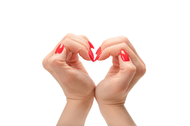 Close up of heart symbol made by woman hands with red nails isolated on a white background. Copy space. - Фото, зображення