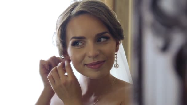 Caucasian, beautiful bride dressed in wedding attire. Portrait of a beautiful bride on the wedding day. Young beautiful girl in the wedding day. Preparation of the bride, decorations, holiday. - Кадры, видео
