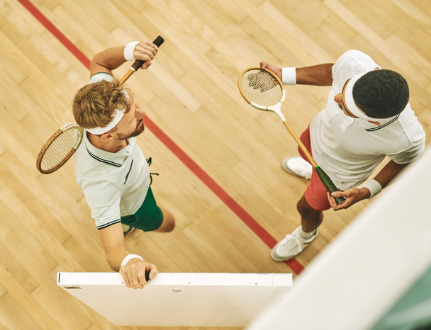 Všichni hvězdní hráči squashe. Vysoký úhel záběru dvou mladých mužů na squash kurtu - Fotografie, Obrázek